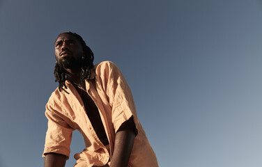 Black man in summer shirt against cloudless sky