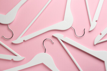 White hangers on pink background, flat lay