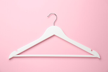 White hanger on pink background, top view