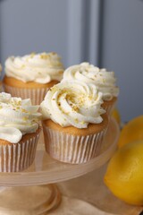 Delicious lemon cupcakes with white cream on table, closeup