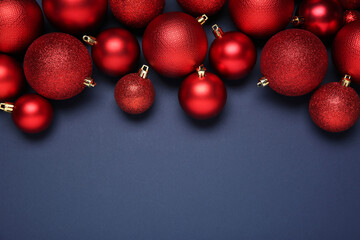 Red Christmas balls on dark blue background, top view. Space for text
