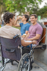 Disabled man and friends having a conversation in the park