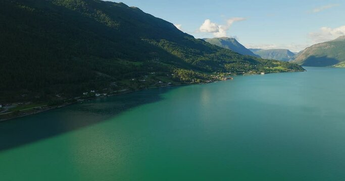 Panoramic aerial overview of quaint town in shadow of stunning fjord in Lustra Fjorden, Norway