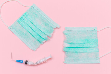 Anti Vaccine Movement and Anti Mask Concept - Broken Medical Syringe and Green Torn Medical Face...