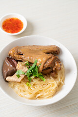 dried noodles with braised duck in white bowl