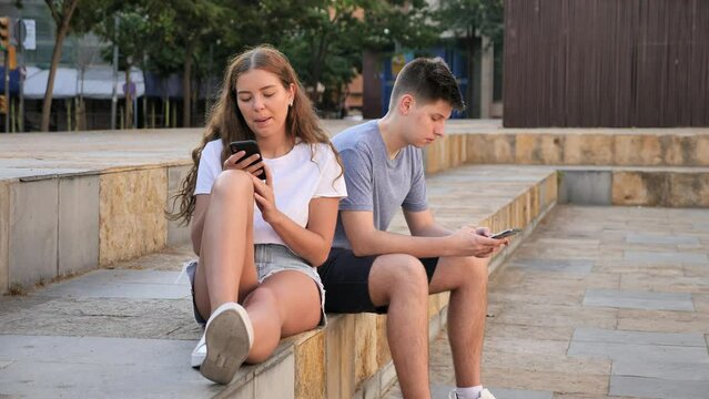  Teenagers are playing on smartphone on city street
