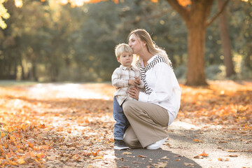 Fototapeta premium Mothers day, love family. Family on autumn walk in nature outdoors. Mother and child with hugging tenderness