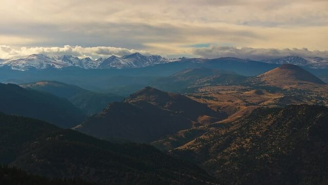 Sweeping mountain vista of forested foothills and snowy ridges of Lost Gulch Overlook Boulder Colorado at sunset