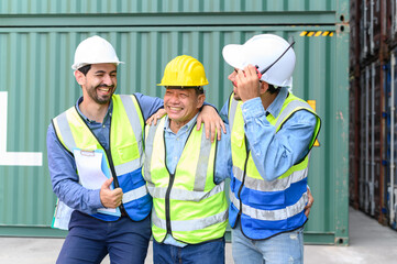 happy professional engineers and foreman container cargo wearing yellow hardhat and safety vests checking stock into container for loading from Cargo freight ship for import export.