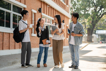 Group of diverse happy Asian college students are enjoying talking after classes on a footpath.