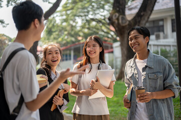 Group of cheerful diverse Asian college students are enjoying talking after classes together.
