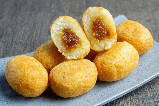 Misro is a typical snack from West Java Indonesia. This snack is made from grated cassava, the inside of which is filled with brown sugar and then fried. served on a plate with a dark table mat