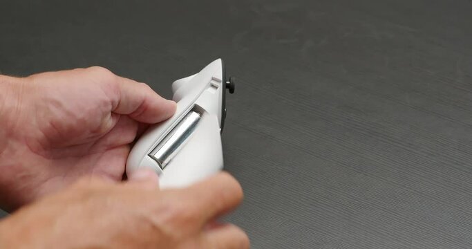 Close-up of male hands changes battery in wireless joystick for VR headset.