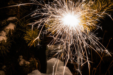 Glittering burning sparkler against blurred background. Sparklers in a glass jar. Christmas background with sparkler in a jar. selective focus.