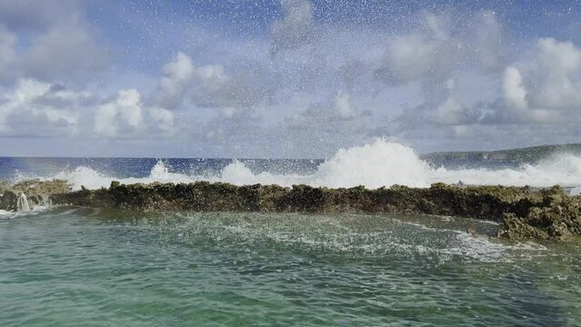 Pan shot of waves crashing on rocks