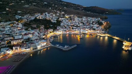 Aerial drone view of  village of Batsi with traditional taverns and clear water beach, Andros island, Cyclades, Greece, at dusk