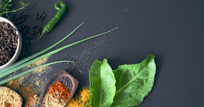 Spices, herbs and condiment for choice, table and powder for curry, wooden spoons and seasoning. Food, natural or different for organic, chilli and spring onion for ingredients, dark backdrop or asia