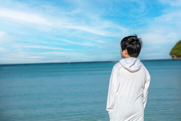 広い海を見つめる少年　A boy staring at the wide ocean