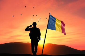 Silhouette of a soldier with the Chad flag stands against the background of a sunset or sunrise. Concept of national holidays. Commemoration Day.