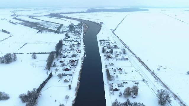 Aerial view The village is located near the river in winter. The house and the surrounding meadows are covered with snow.