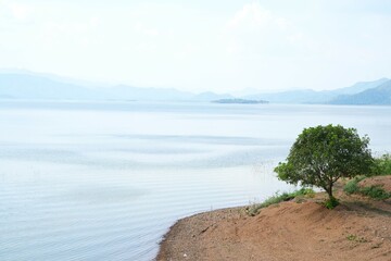 Water wave in the lake, sunny day in 
 morning with blue clouds sky on mountain range background in Kaeng Krachan National Park in Thailand.