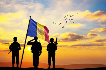 Silhouettes of soldiers with the Andorra flag stand against the background of a sunset or sunrise. Concept of national holidays. Commemoration Day.