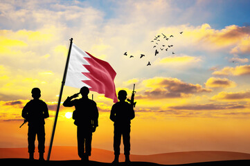 Silhouettes of soldiers with the Bahrain flag stand against the background of a sunset or sunrise. Concept of national holidays. Commemoration Day.