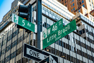 The sign at the intersection of Fifth Avenue and Little Barsil Street, with skyscrapers in the background, is located in the heart of Manhattan, in the heart of the Big Apple of New York in the USA.