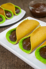 kue manja with chocolate filling served on a white plate 