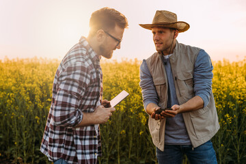 Two Caucasian man examining quality of the soil in the fields.