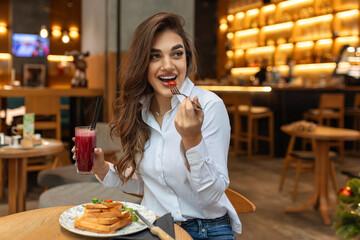 Young smiling woman eat breakfast lunch cucumber toast sandwich and drinking juice Healthy diet...