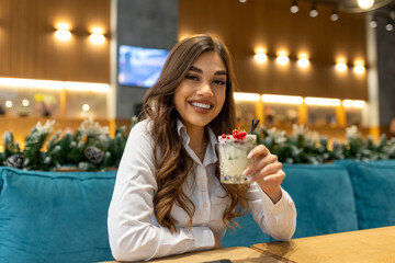 Smiling confident young woman drinking cocktail, portrait of an woman drinking cocktails, sitting...
