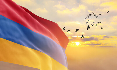 Waving flag of Armenia against the background of a sunset or sunrise. Armenia flag for Independence Day. The symbol of the state on wavy fabric. - obrazy, fototapety, plakaty