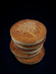 Beautiful round cookies on a black background. A few cookies. Cookie tower.