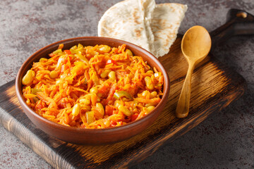 Chakalaka is a vegetarian South African dish which can fit into many categories it can be a salsa, a relish, a condiment, or a main dish closeup on the bowl on the table. Horizontal