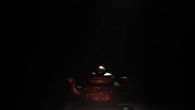A clay teapot in a ray of light