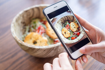 restaurant owner takes a picture of the food on the table with a smartphone to post on a website. Online food delivery, ordering service, influencer, review, social media, share, marketing, interes