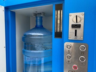 The vending machine pours water for money, pure spring water in a bottle, a bottle of clean water,...