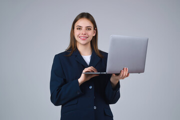 Business woman with laptop , studio portrait. Young Businesswoman holding laptop, isolated on gray....