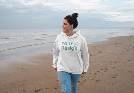 Mockup of woman wearing customizable hoodie by sea