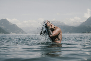 Muscular Hispanic man splashing water in lake. Attractive male sexy model in water. Handsome boy...