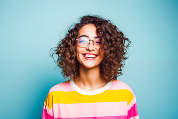 Curly-haired woman laughing in colorful sweater, lively and joyful.