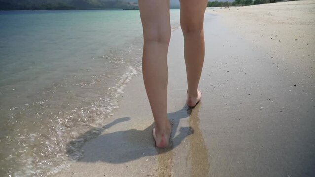 Close Up Slow Motion Shot of Female Legs and Feet Walking Through Shallow Water on Tropical Beach