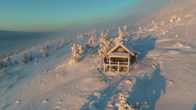 Aerial view away from a skier at the Santa's cabin, frosty sunset in Lapland