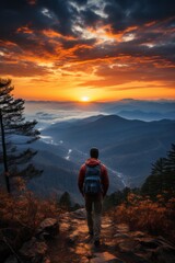 Fototapeta premium Solitary hiker pausing to enjoy the striking colors of a spring sunset in the mountains, Generative AI 