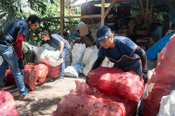 Young Hispanic Workers Stacking Recycled Glass Bottles at Recycling Site