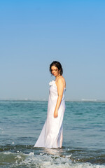 Fototapeta na wymiar Beautiful bride in a white wedding dress on the seashore