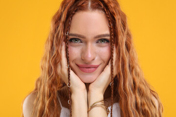 Beautiful young hippie woman on orange background, closeup