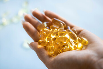 Close-up medicine yellow transparent pills, omega 3 fish oil capsules, vitamin D. Many yellow...