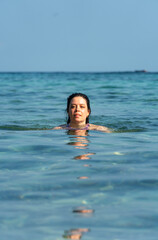 Portrait of pretty young woman swimming in the ocean